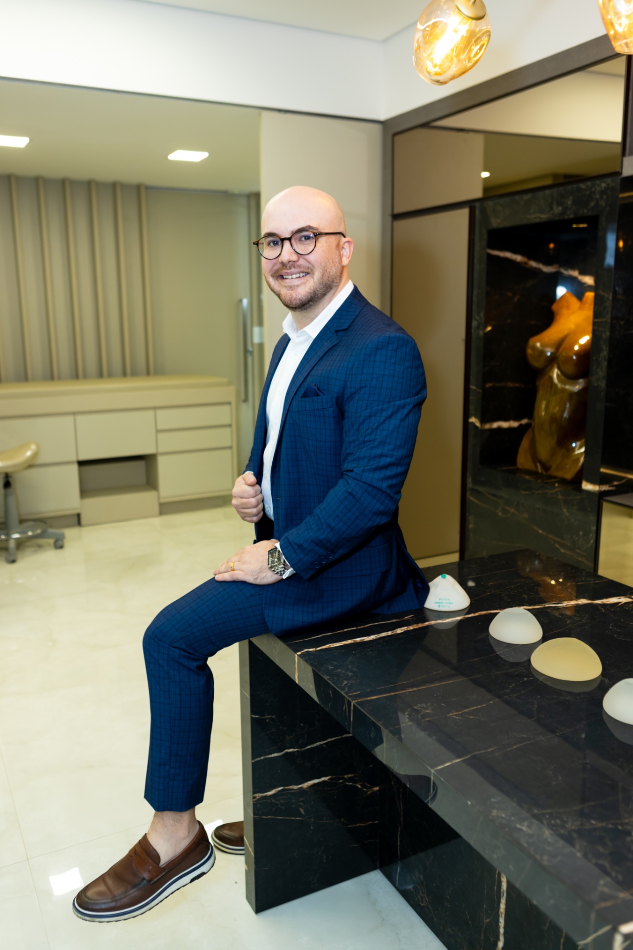 Dr. Francisco Moreira no consultório com modelos de prótese